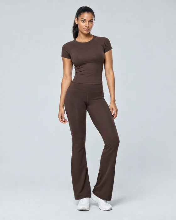 Model in an espresso sports top and flared leggings